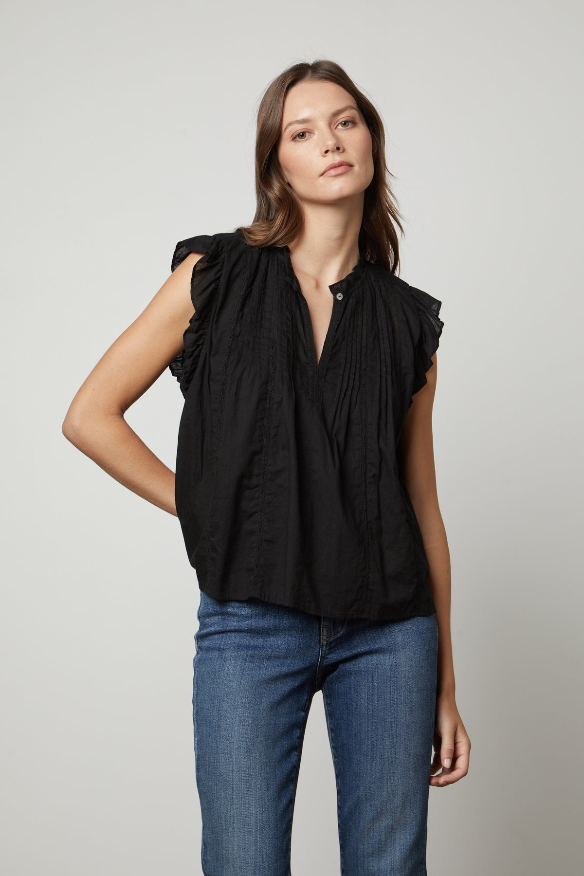   The model is wearing a LIANA LACE TANK TOP from Velvet by Graham & Spencer with ruffled sleeves. 
