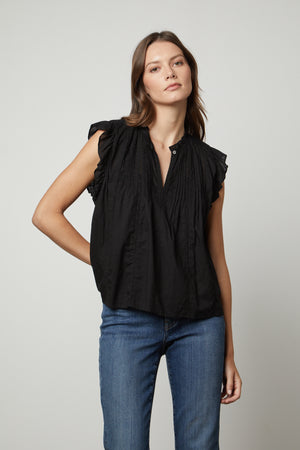 The model is wearing a LIANA LACE TANK TOP from Velvet by Graham & Spencer with ruffled sleeves.