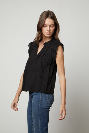 The model is wearing a LIANA LACE TANK TOP by Velvet by Graham & Spencer with ruffled sleeves.