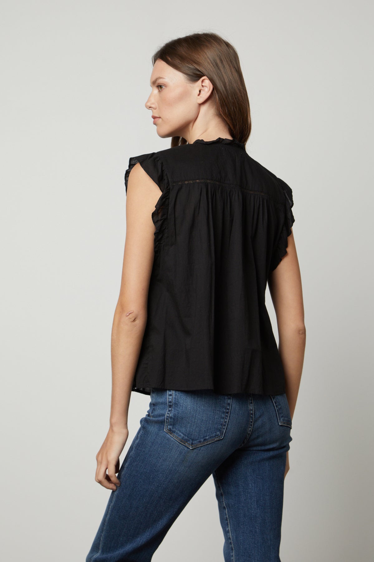   The back view of a woman wearing a Velvet by Graham & Spencer LIANA LACE TANK TOP and jeans. 
