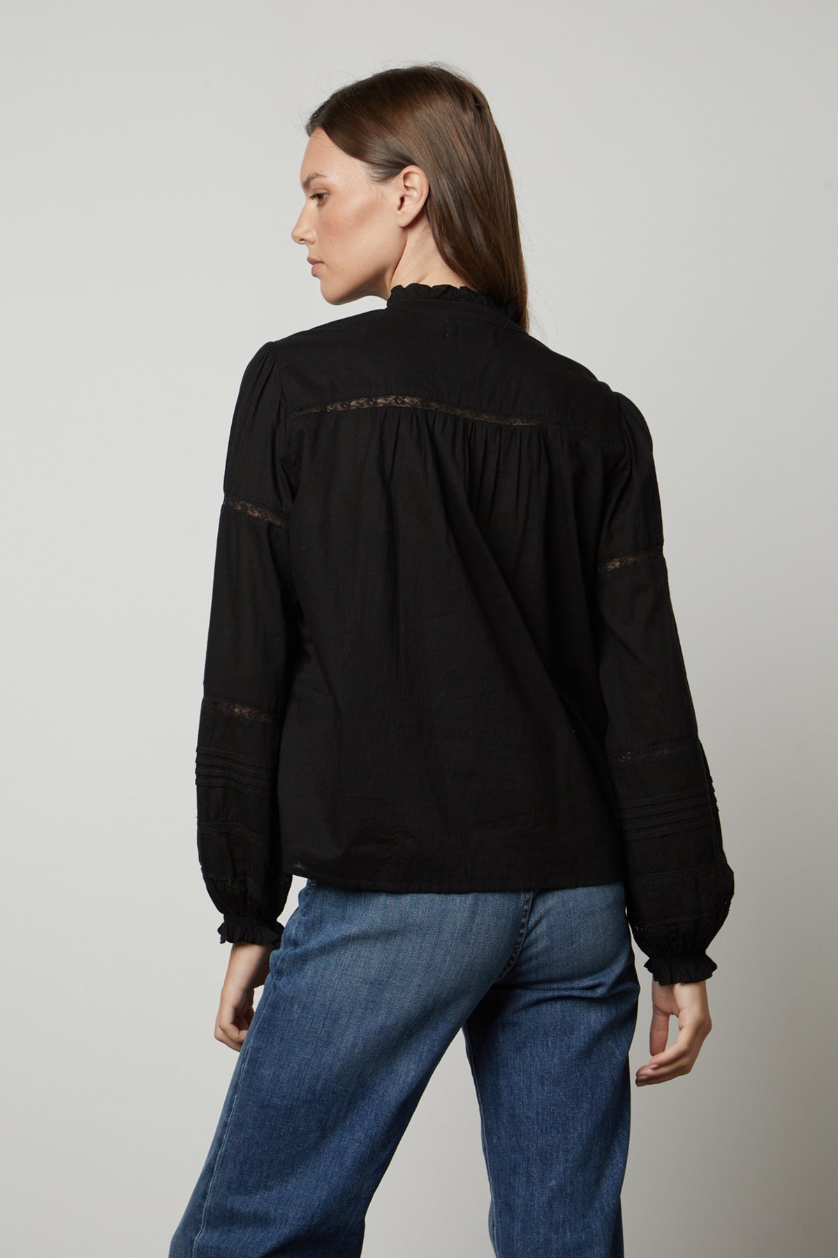 The back view of a woman wearing a Velvet by Graham & Spencer ROMY LACE BOHO TOP blouse and jeans.-26834995740865
