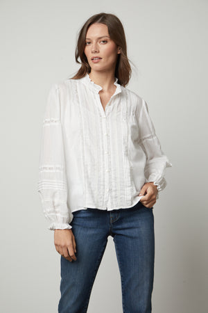 The model is wearing Velvet by Graham & Spencer jeans and a Velvet by Graham & Spencer white blouse.