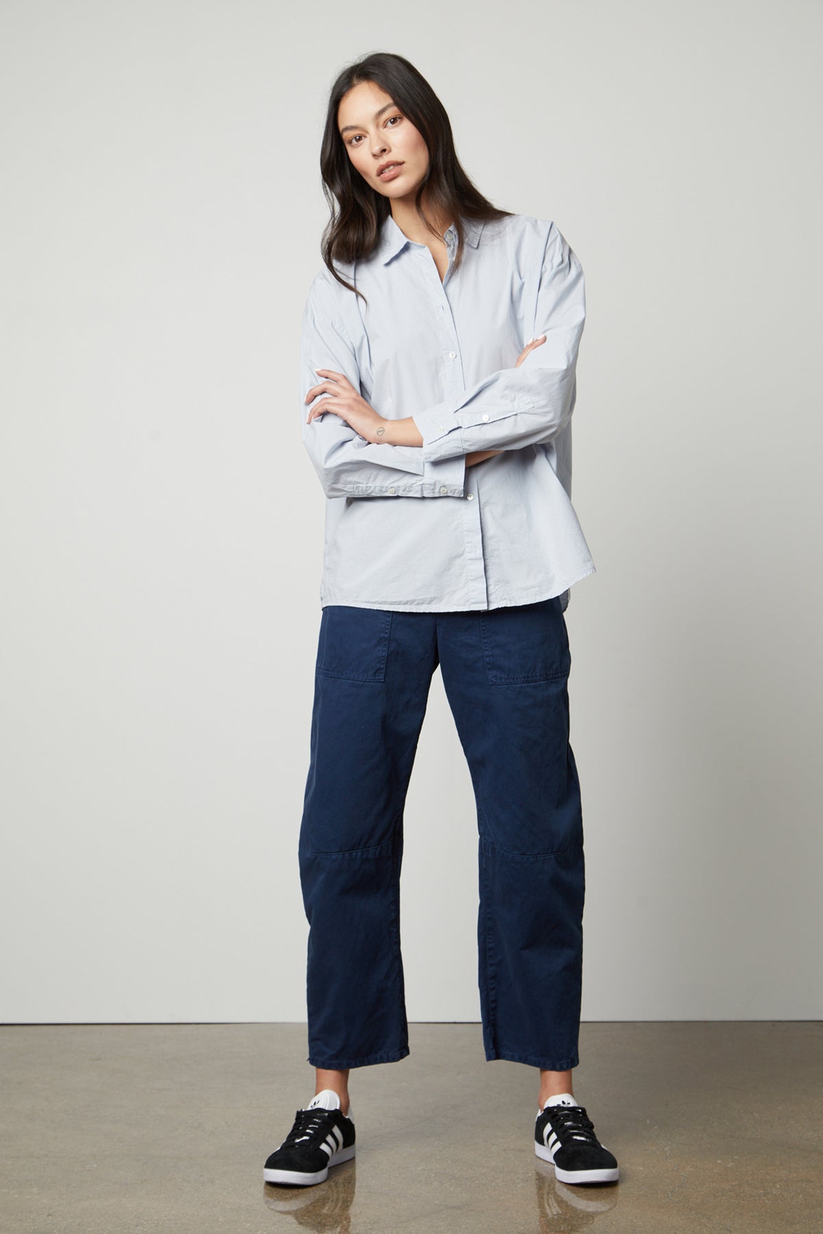   The model is wearing a Velvet by Graham & Spencer BRYLIE SANDED TWILL UTILITY PANT and blue shirt. 