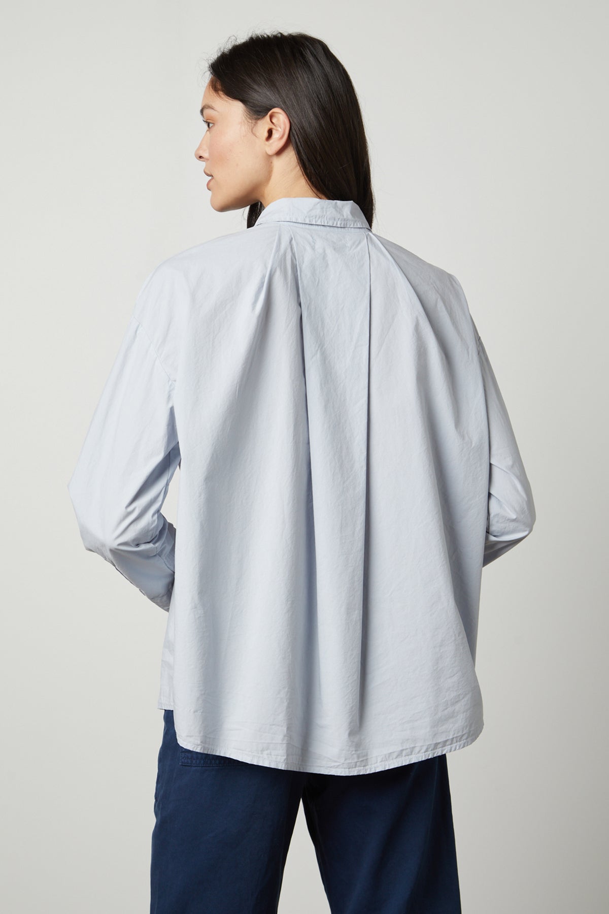 The back view of a woman wearing a Velvet by Graham & Spencer DAKOTA BUTTON-UP SHIRT.-26914845753537