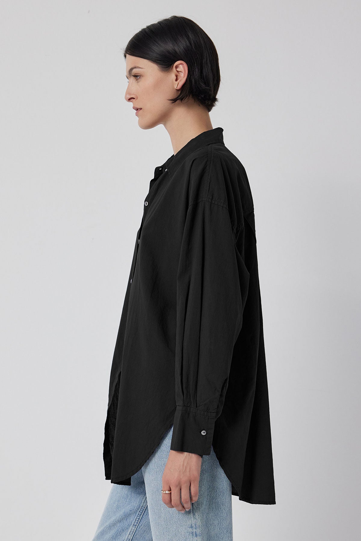   The back view of a woman wearing an oversized black Velvet by Jenny Graham REDONDO BUTTON-UP SHIRT. 