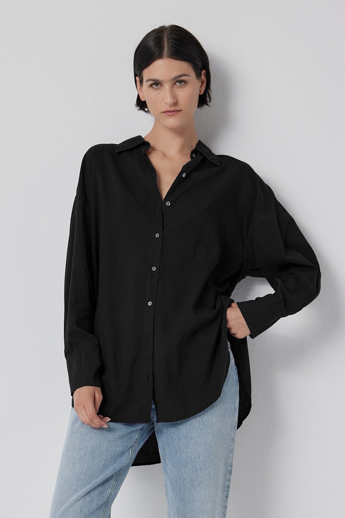   The model is wearing an oversized black REDONDO BUTTON-UP SHIRT and jeans by Velvet by Jenny Graham. 