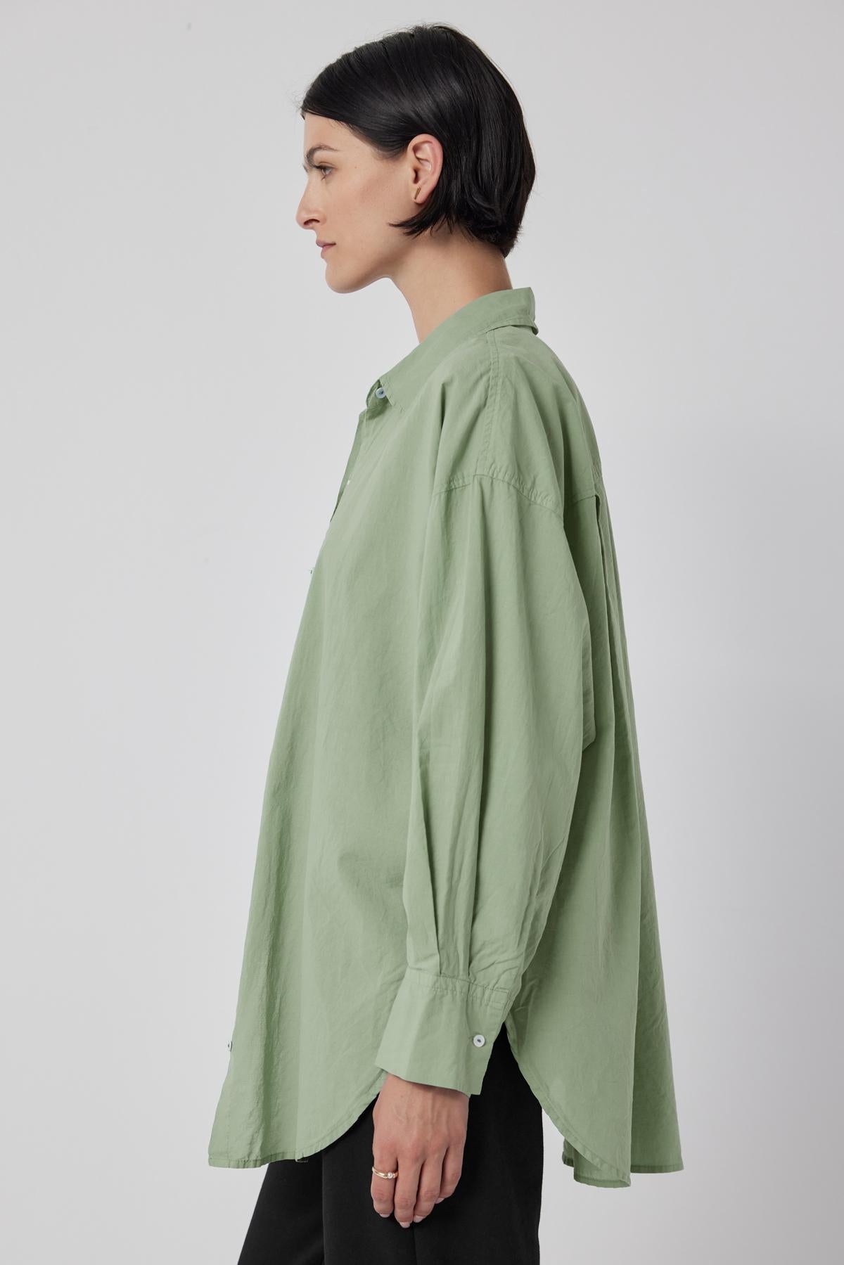 The oversized green Redondo Button-Up Shirt from Velvet by Jenny Graham worn by a woman.-36198180061377