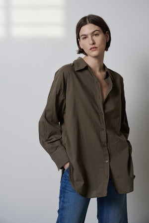 The model is wearing an oversized Velvet by Jenny Graham REDONDO BUTTON-UP SHIRT and jeans.