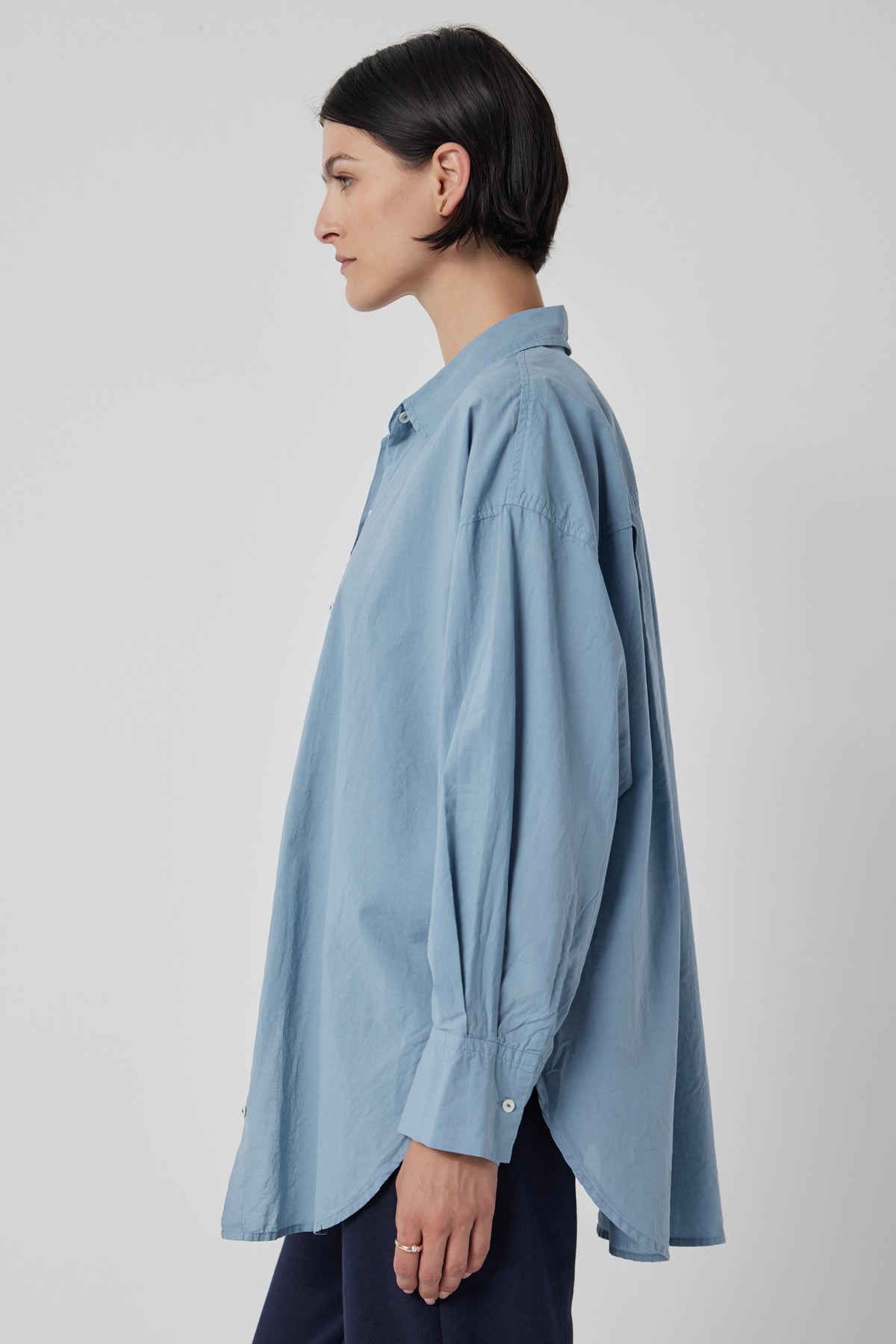 The back view of a woman wearing an oversized blue cotton Velvet by Jenny Graham REDONDO BUTTON-UP SHIRT with drop shoulder.-36168811020481
