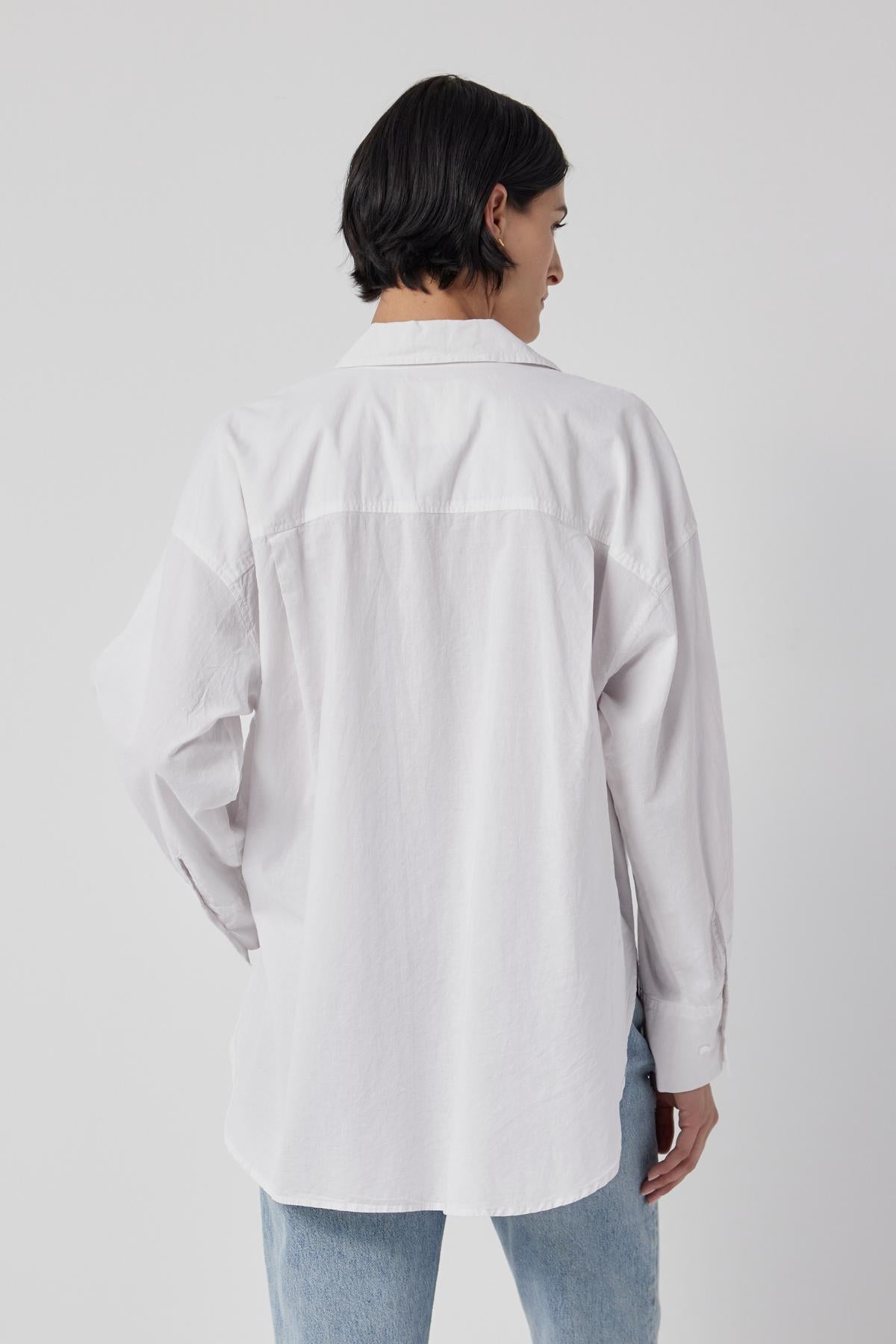 The back view of a woman wearing an oversized Velvet by Jenny Graham Redondo Button-Up Shirt, embracing the borrowed-from-the-boys silhouette fashion trend.-26861789216961
