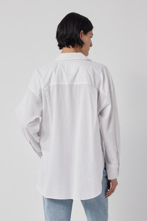 The back view of a woman wearing an oversized Velvet by Jenny Graham Redondo Button-Up Shirt, embracing the borrowed-from-the-boys silhouette fashion trend.