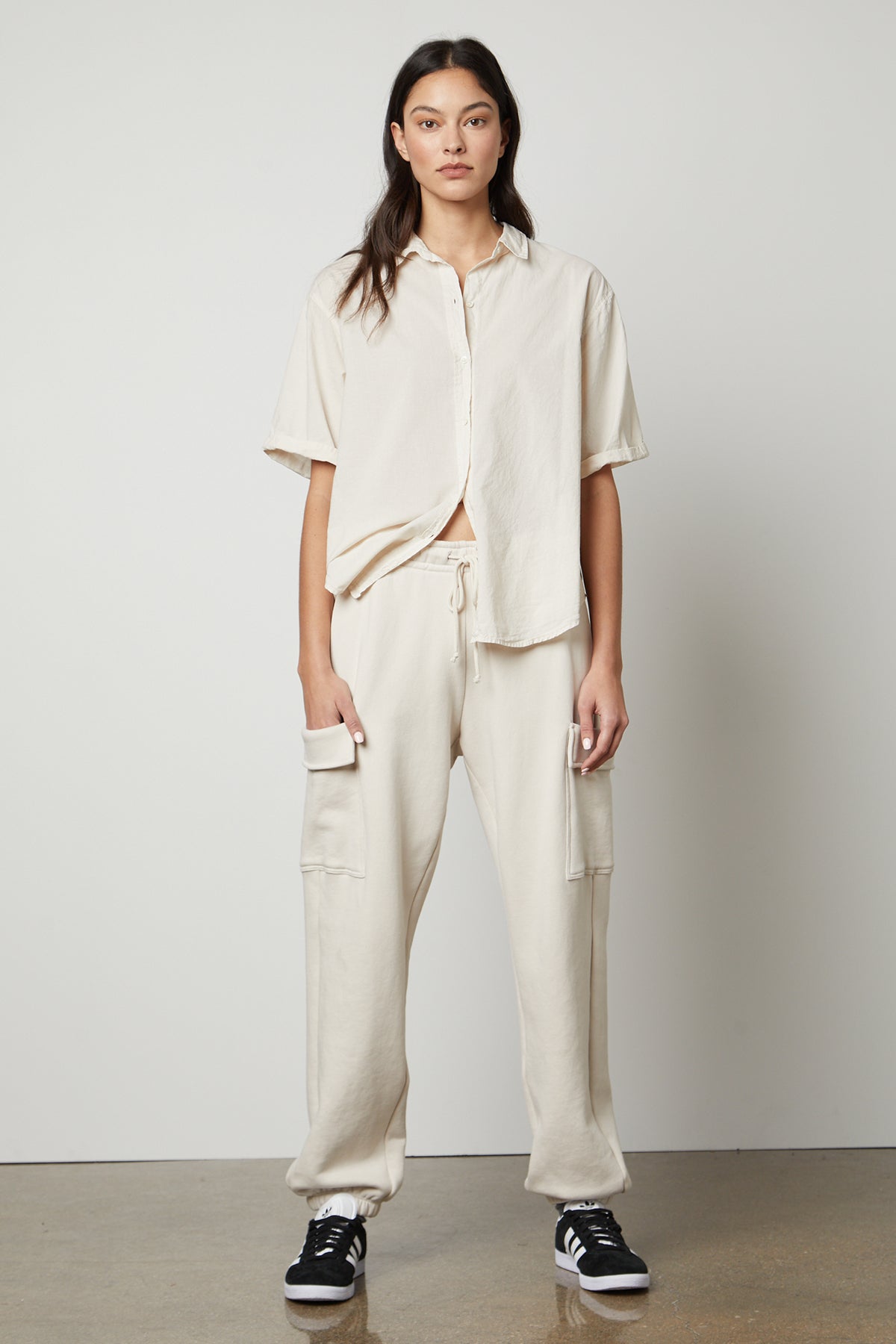 The model is wearing a white sweatshirt and Velvet by Graham & Spencer LUMI DRAWSTRING WAIST SWEATPANT.-35656846213313