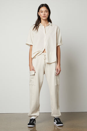 The model is wearing a white sweatshirt and Velvet by Graham & Spencer LUMI DRAWSTRING WAIST SWEATPANT.