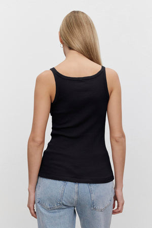 Woman wearing a black Aliza ribbed cotton layering tank from Velvet by Graham & Spencer and blue jeans viewed from the back.