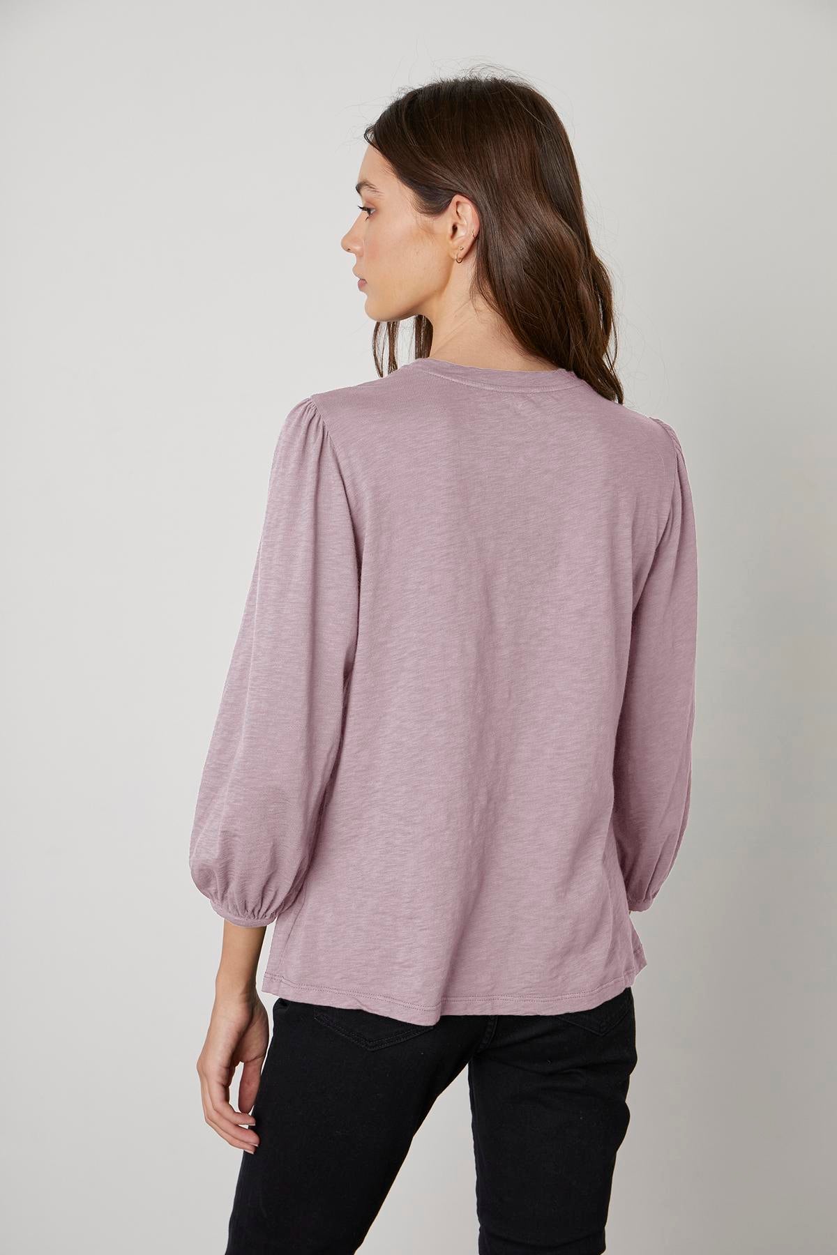 The back view of a woman wearing the Velvet by Graham & Spencer ANETTE PUFF SLEEVE TEE.-35416302616769