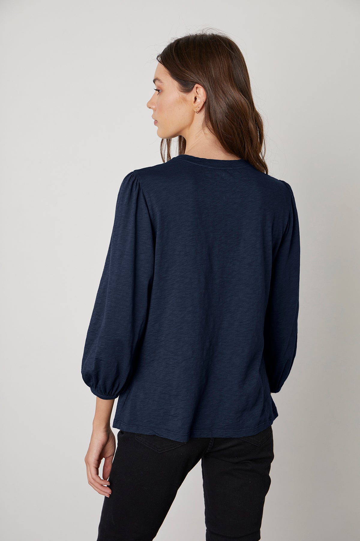   The back view of a woman wearing Anette Puff Sleeve Tee by Velvet by Graham & Spencer. 