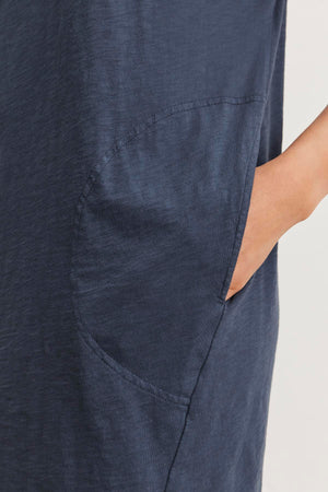 Close-up of a person’s hand resting in the pocket of an ATHENA DRESS by Velvet by Graham & Spencer, highlighting the relaxed fit and soft cotton slub fabric.