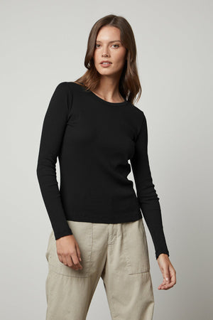 The model is wearing a BAYLER RIBBED SCOOP NECK TEE by Velvet by Graham & Spencer and beige pants.