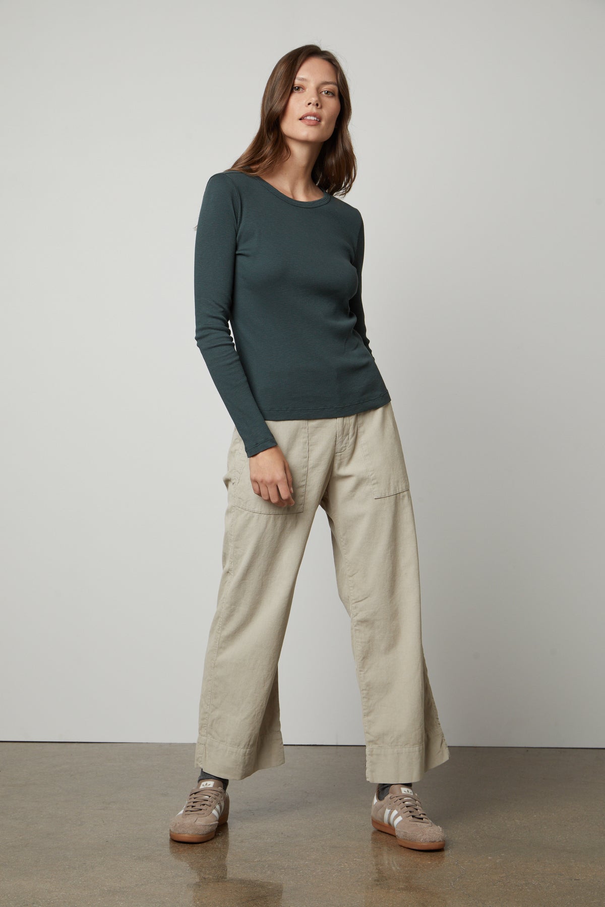   The model is wearing a Velvet by Graham & Spencer BAYLER RIBBED SCOOP NECK TEE and khaki pants. 