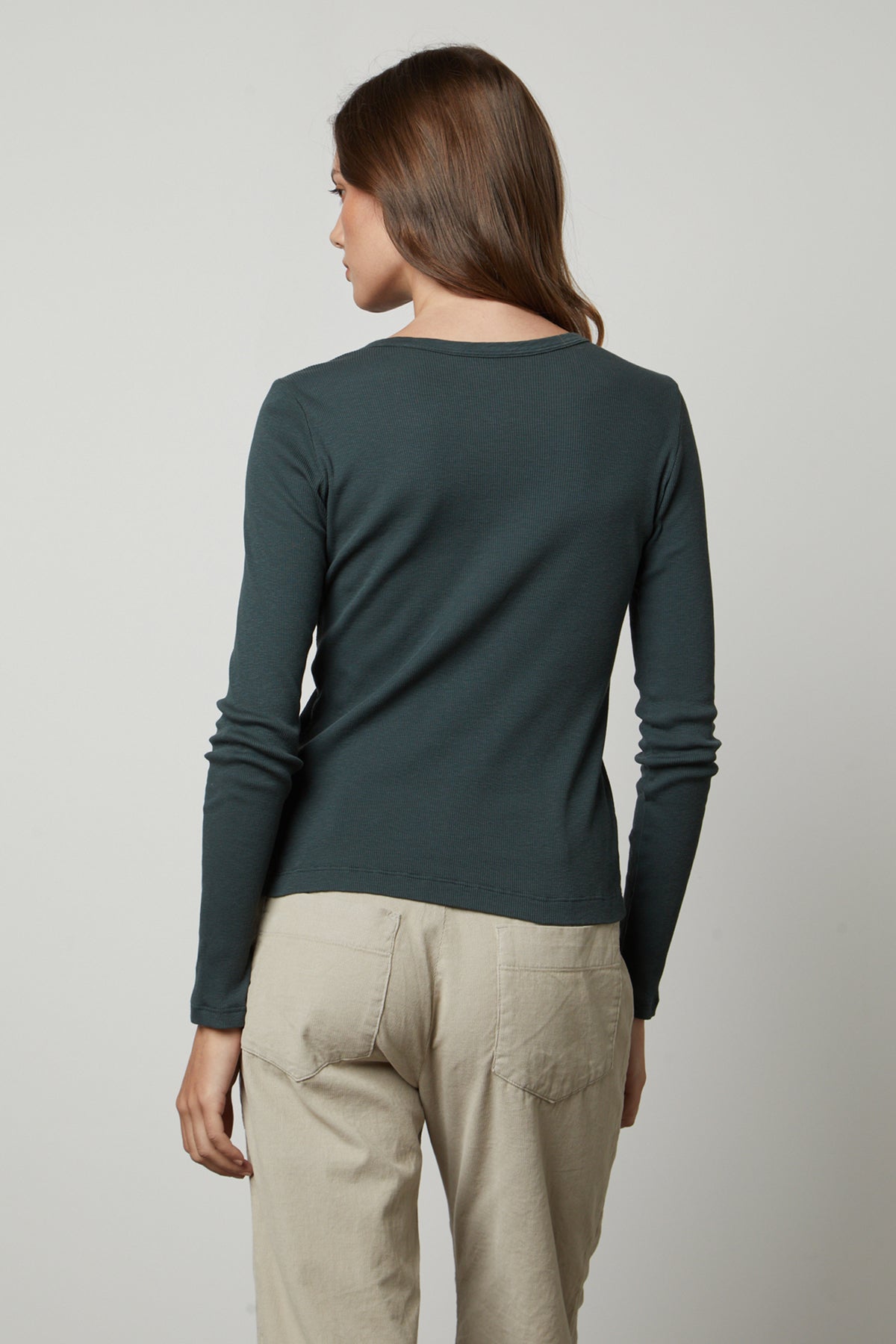   The back view of a woman wearing a Velvet by Graham & Spencer BAYLER RIBBED SCOOP NECK TEE top and khaki pants. 