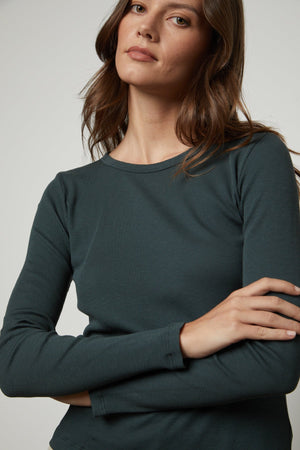 The model is wearing a Velvet by Graham & Spencer BAYLER RIBBED SCOOP NECK TEE.