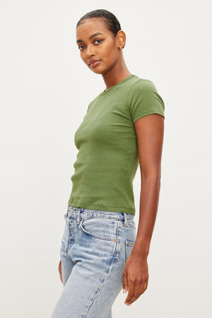 A woman wearing a Velvet by Graham & Spencer Brenny Ribbed Crew Neck Tee in a ribbed cotton knit, paired with jeans.