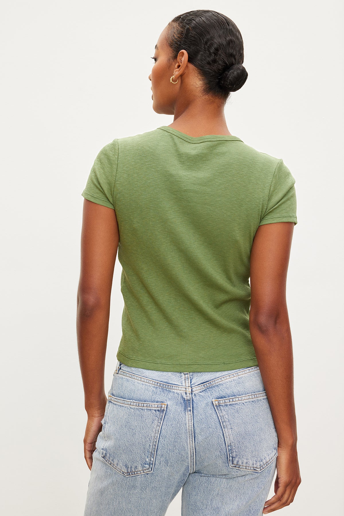   The back view of a woman wearing jeans and a Velvet by Graham & Spencer BRENNY RIBBED CREW NECK TEE, featuring a slightly cropped silhouette in ribbed cotton knit. 