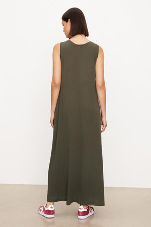 The back view of a woman wearing a green sleeveless Velvet by Graham & Spencer EDITH SLEEVELESS MAXI DRESS.