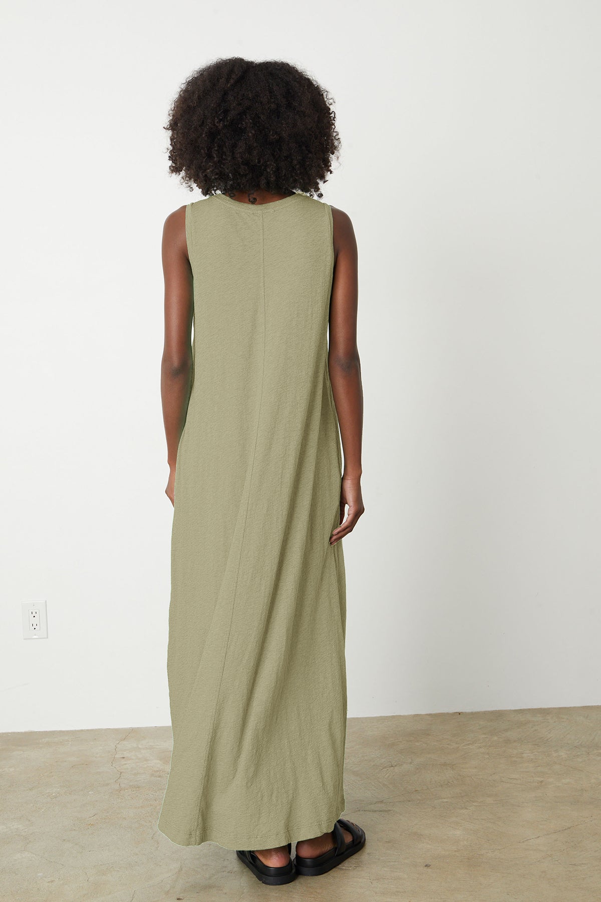 the back view of a woman wearing an EDITH SLEEVELESS MAXI DRESS by Velvet by Graham & Spencer.-26342821986497