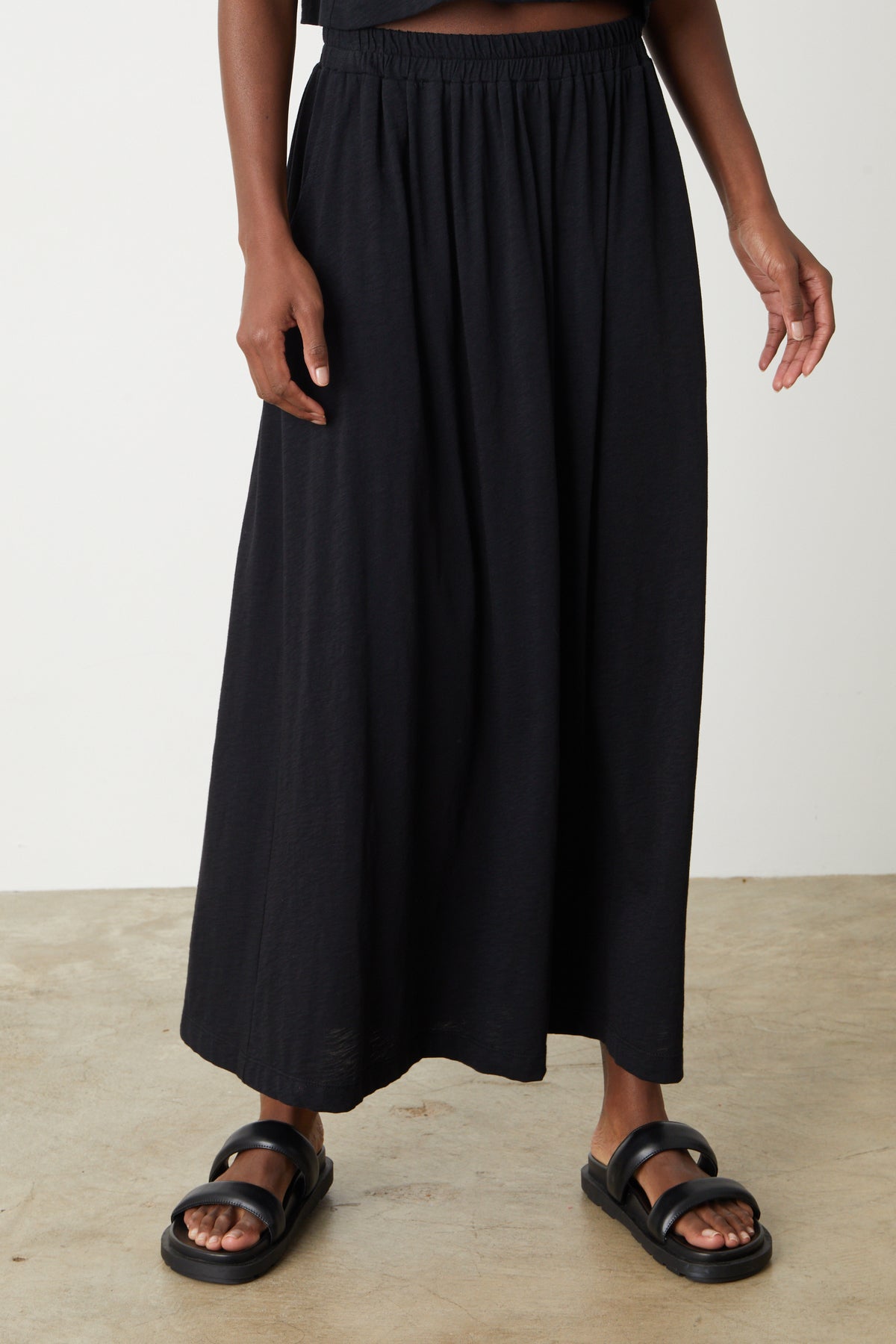 A woman wearing a Velvet by Graham & Spencer GWEN COTTON SLUB MAXI SKIRT and sandals.-26559921455297