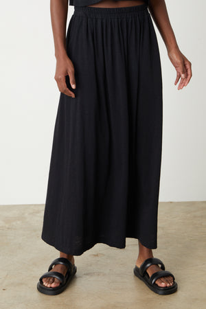A woman wearing a Velvet by Graham & Spencer GWEN COTTON SLUB MAXI SKIRT and sandals.