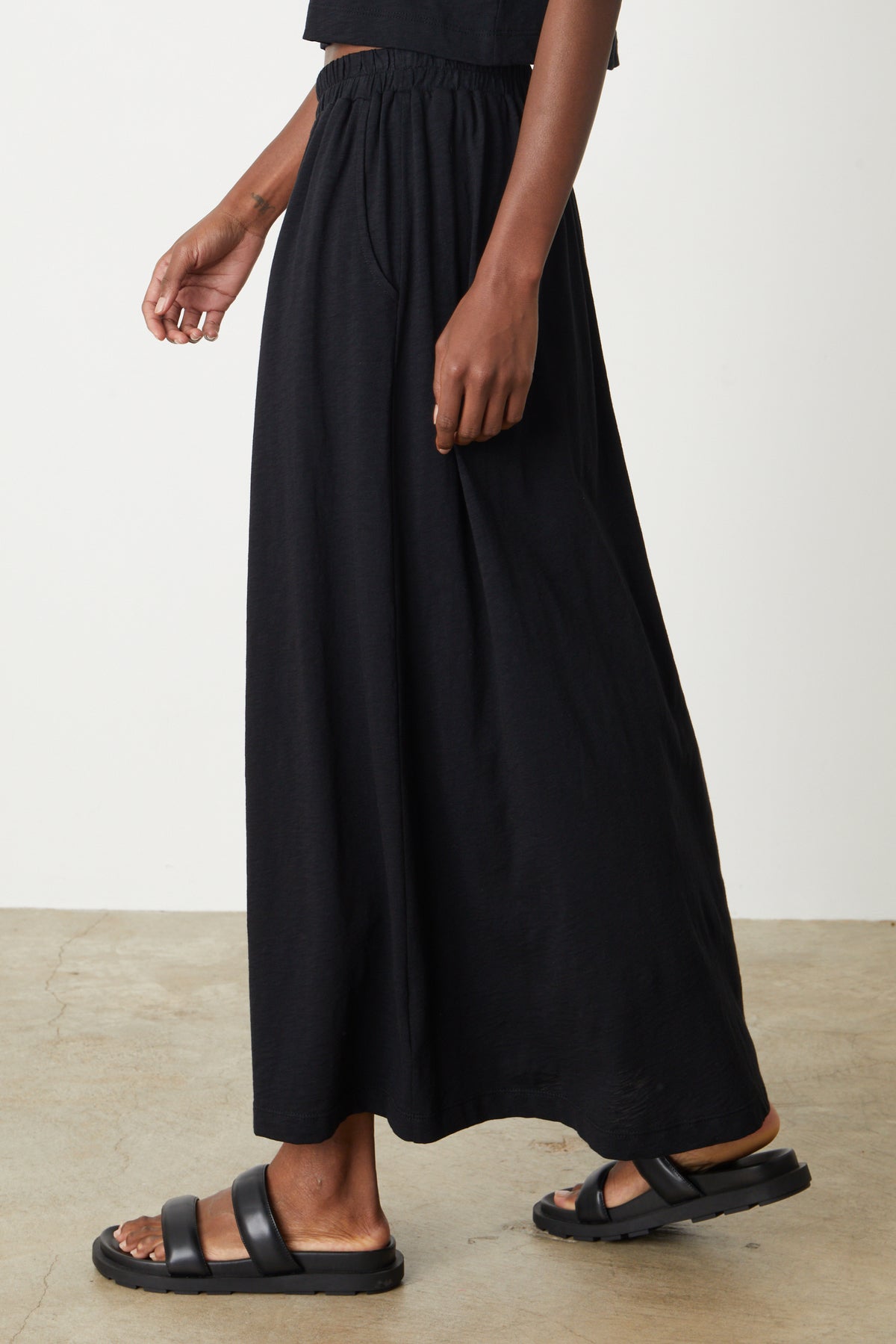   A woman wearing the Velvet by Graham & Spencer GWEN COTTON SLUB MAXI SKIRT and sandals. 