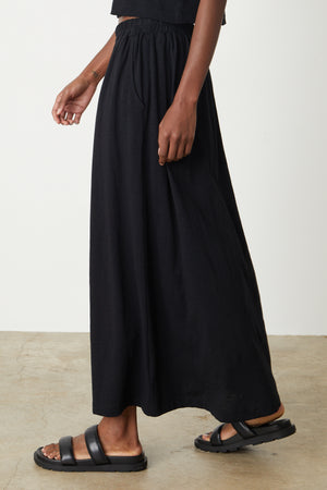 A woman wearing the Velvet by Graham & Spencer GWEN COTTON SLUB MAXI SKIRT and sandals.