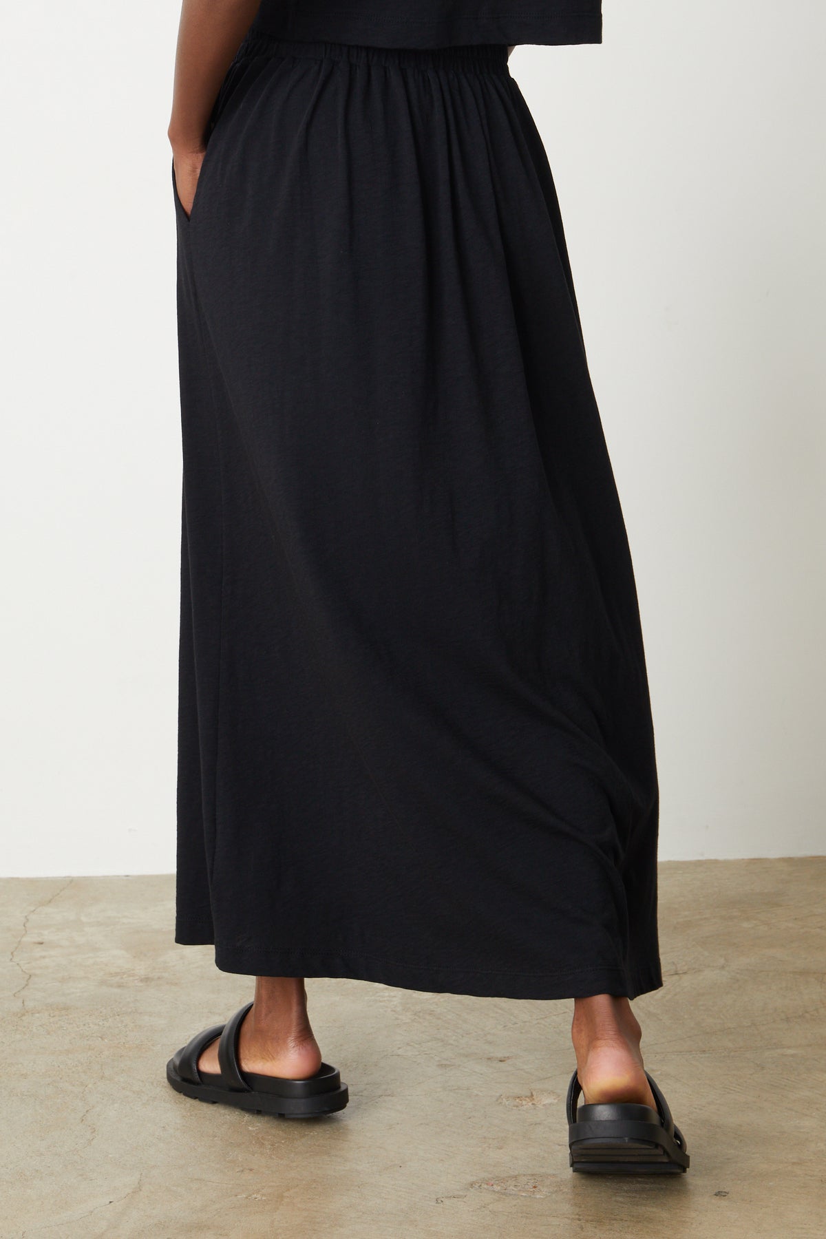 The back view of a woman wearing a Velvet by Graham & Spencer COTTON SLUB MAXI SKIRT.-26559921553601