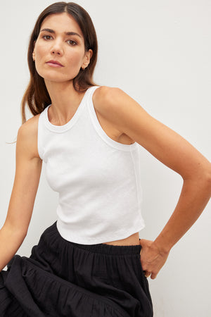 A woman wearing a Velvet by Graham & Spencer's HARLA RIBBED CROPPED TANK TOP and black skirt.