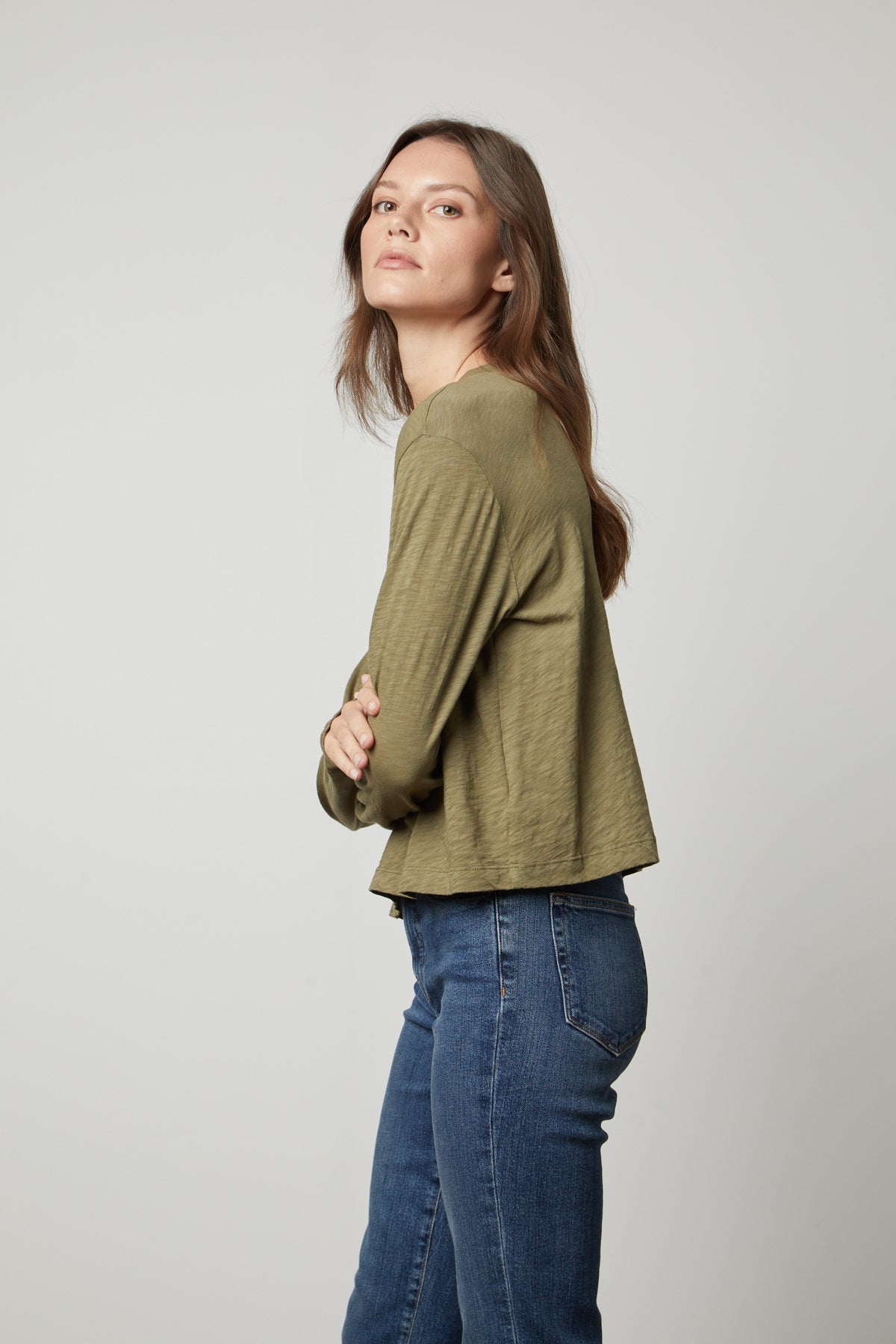   The model is wearing Velvet by Graham & Spencer jeans and a HEATHER CREW NECK CROPPED TEE in olive green. 