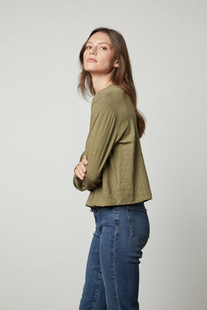 The model is wearing Velvet by Graham & Spencer jeans and a HEATHER CREW NECK CROPPED TEE in olive green.