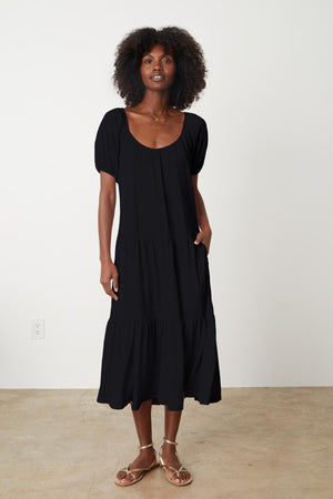 A woman wearing a Velvet by Graham & Spencer JANE SCOOP NECK TIERED DRESS and sandals.