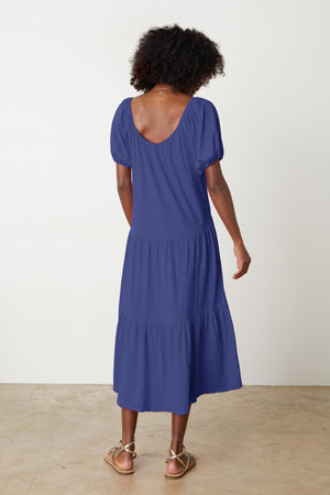 The back view of a woman wearing a Velvet by Graham & Spencer JANE SCOOP NECK TIERED DRESS.