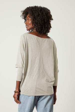 The back view of a woman wearing a Velvet by Graham & Spencer JOSS DOLMAN SLEEVE TEE and jeans.