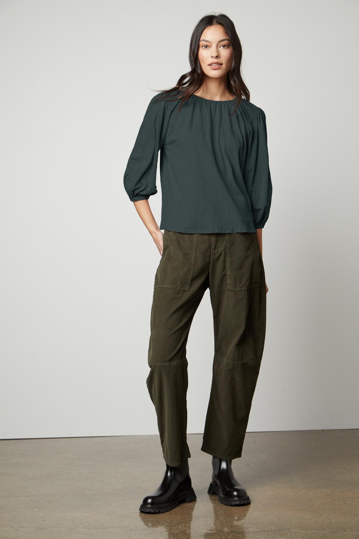 The model is wearing olive trousers and a Velvet by Graham & Spencer JULIE 3/4 SLEEVE TEE.-26727740178625