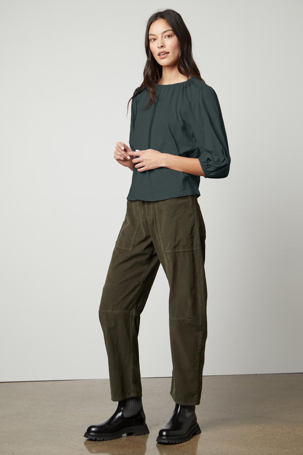   The model is wearing a green SUE CORDUROY PANT with puff sleeves. 