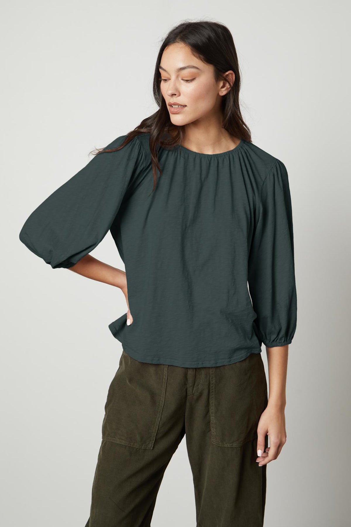 The model is wearing a Velvet by Graham & Spencer Julie 3/4 Sleeve Tee with puff sleeve.-26727740145857
