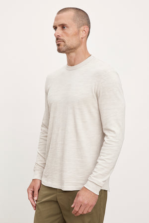 A man wearing a Palmer Crew Neck Tee by Velvet by Graham & Spencer and khaki pants.