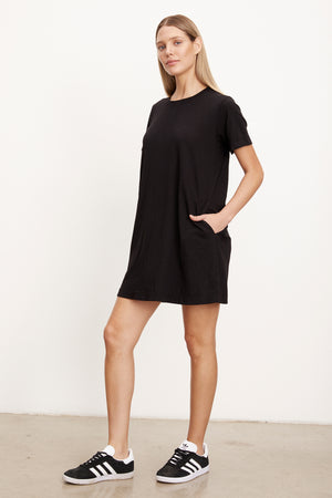 A model wearing a LEIGH COTTON SLUB DRESS by Velvet by Graham & Spencer and sneakers.