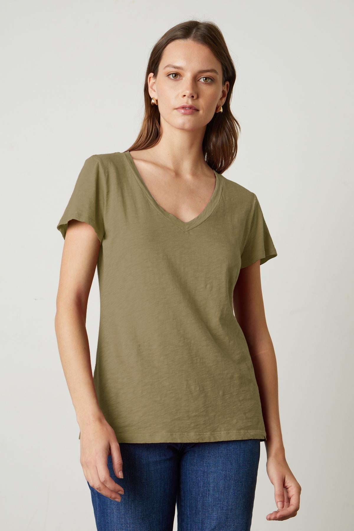 A woman with a preppy tomboy style wearing a Velvet by Graham & Spencer LILITH COTTON SLUB V-NECK TEE in green.-35782982369473