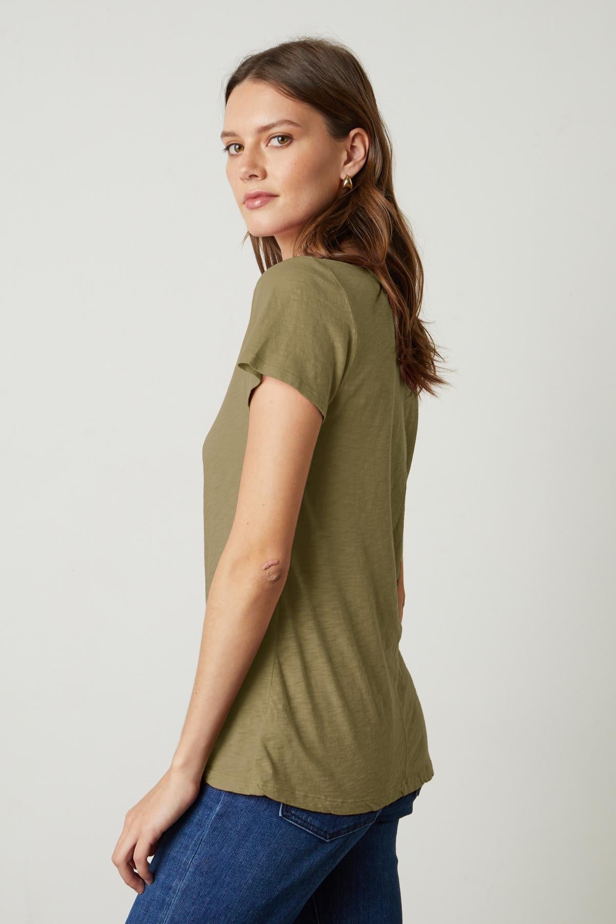   The back view of a woman wearing a green Velvet by Graham & Spencer LILITH COTTON SLUB V-NECK TEE. 