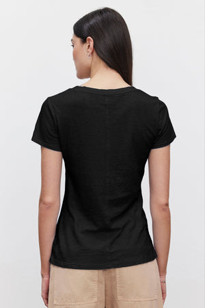 The woman is wearing a black LILITH COTTON SLUB V-NECK TEE, showing off the tomboy style from Velvet by Graham & Spencer.