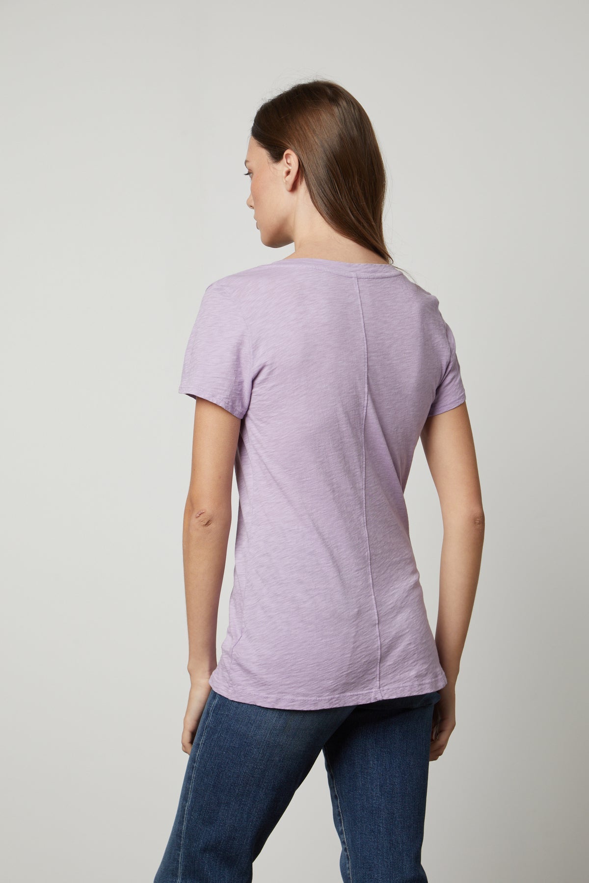 The back view of a woman wearing a Velvet by Graham & Spencer LILITH COTTON SLUB V-NECK TEE.-35782982172865