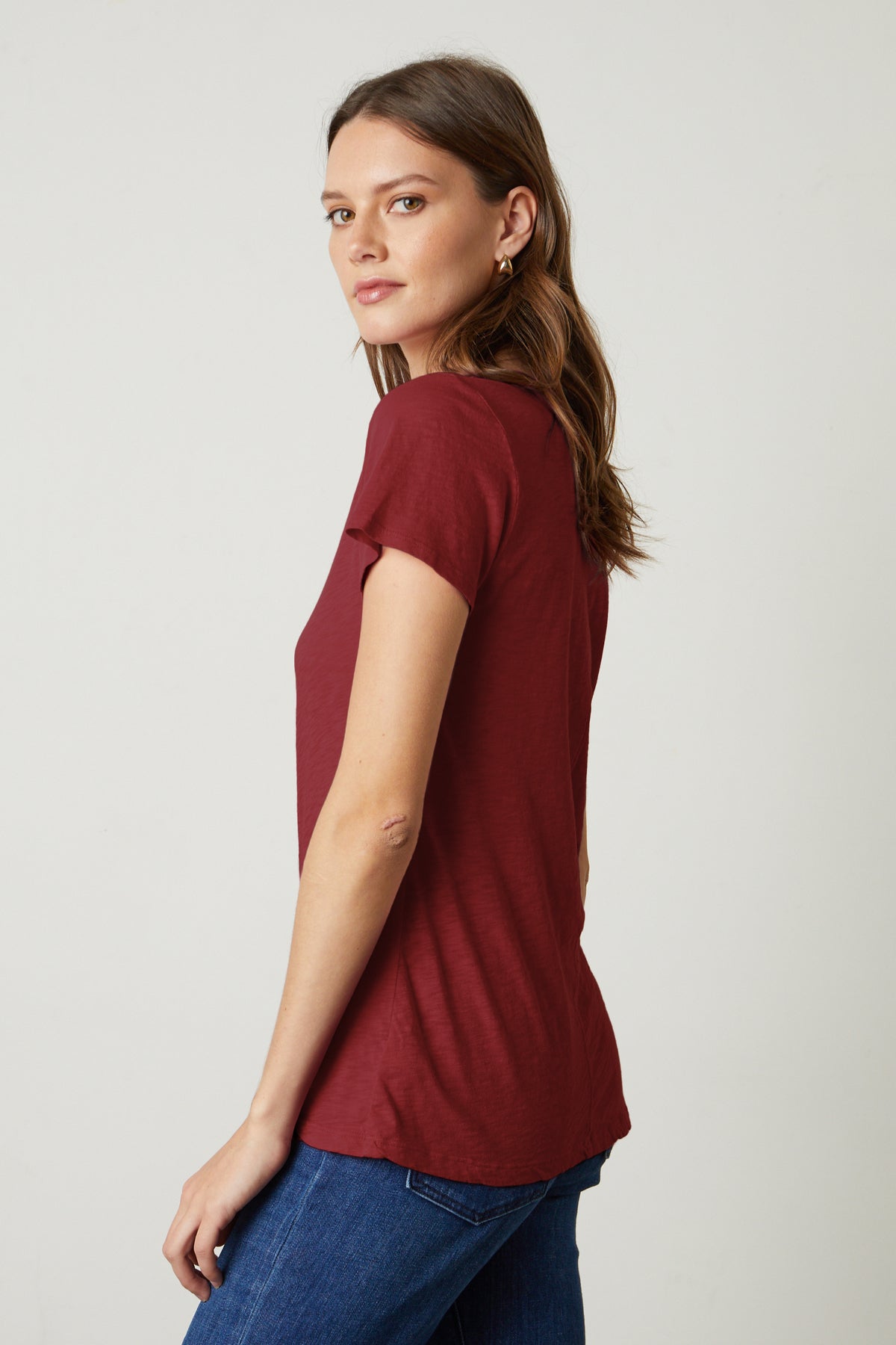 The back view of a woman wearing a Velvet by Graham & Spencer LILITH COTTON SLUB V-NECK TEE.-35782982303937